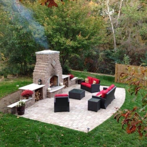 Outdoor living space with stone fireplace and custom paver patio
