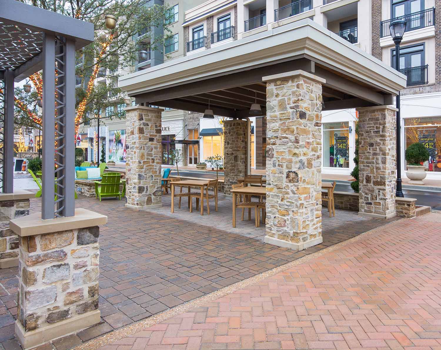 Custom brick pathway with stone pillars for a covered seating area