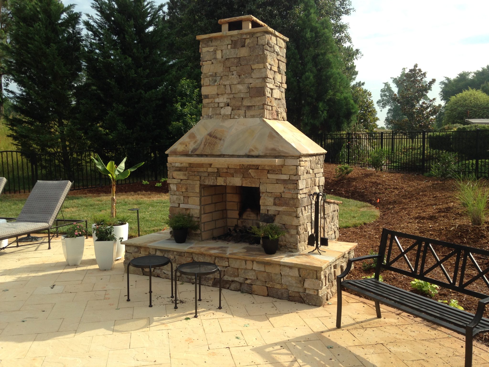 Outdoor living space with stone fireplace and custom paver patio