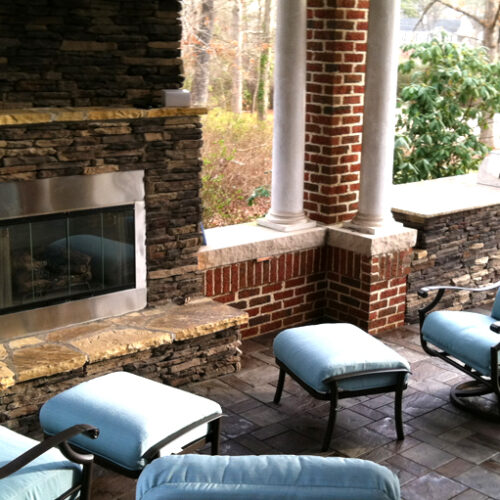 Outdoor living space with stone and gas fireplace, retaining wall, outdoor kitchen and custom paver patio