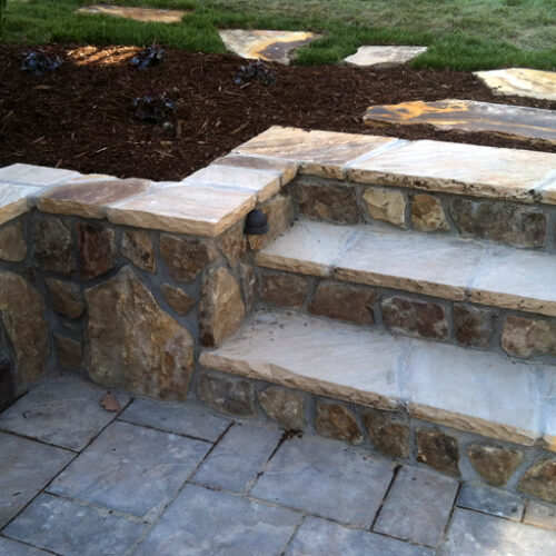 Outdoor living space with retaining wall and custom paver patio