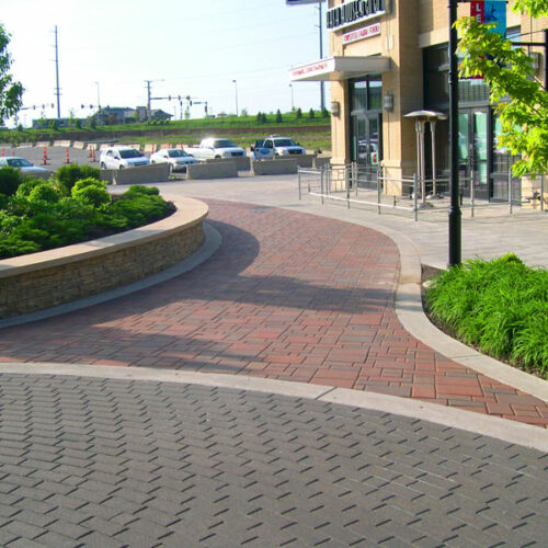 Plaza walkway with custom bricks and patio pavers with retaining walls holding flower beds