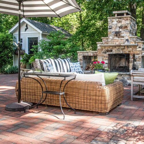 Outdoor living space with stone fireplace, retaining wall and custom patio paver
