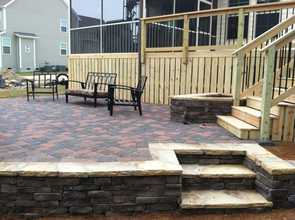 Outdoor living space with stone fire pit, retaining wall and custom paver patio