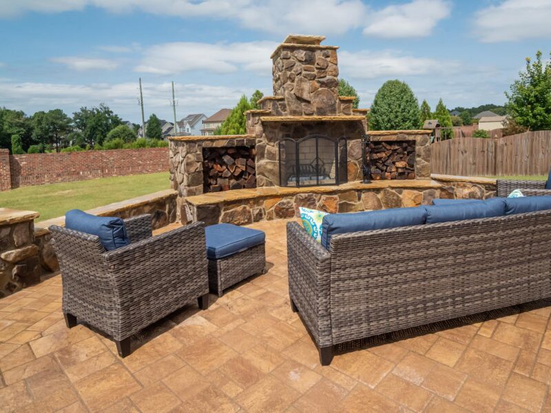 Outdoor living space with stone fireplace, retaining wall and custom paver patio